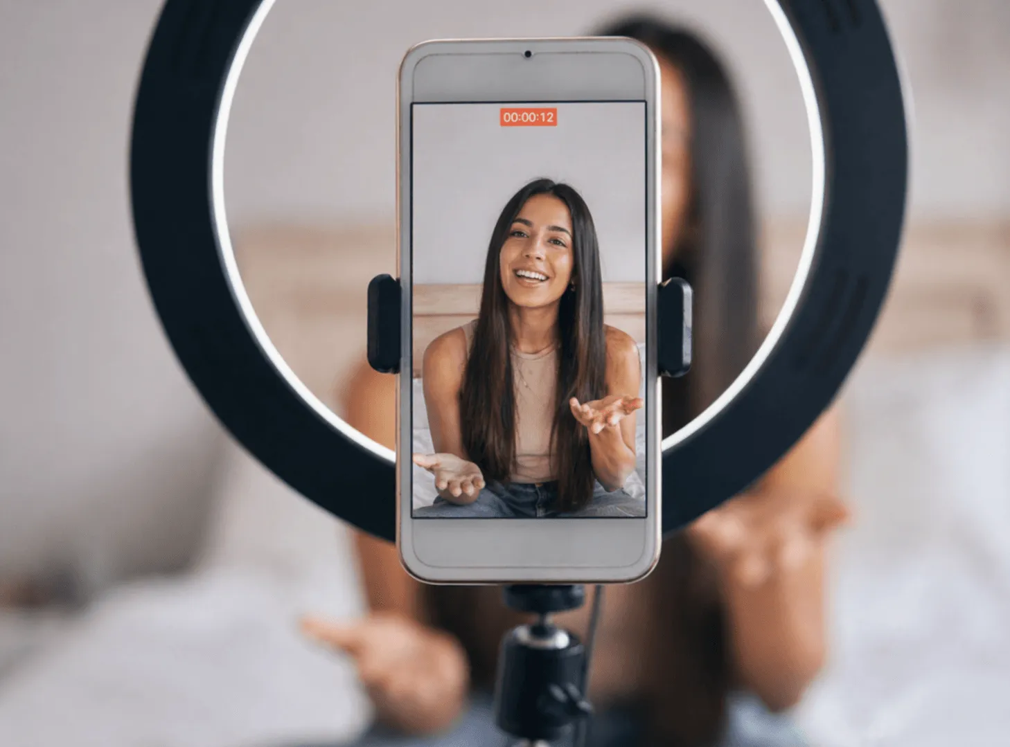 Mujer grabando un vídeo con su smartphone y un aro de luz